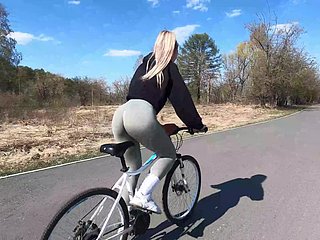 Une cycliste fair-haired montre lassie copain pêche à lassie partenaire et baise dans un parc public